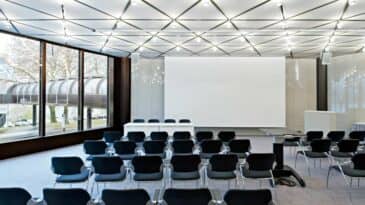 Raum 13 mit Reihenbestuhlung und Podium